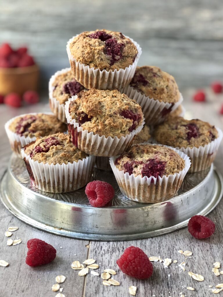 Raspberry oat muffins stacked on tray
