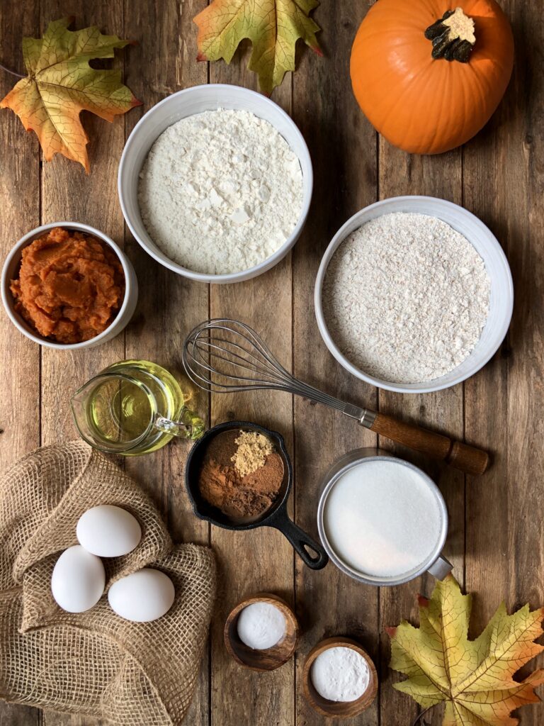Flour, sugar, eggs, pumpkin puree arranged on counter
