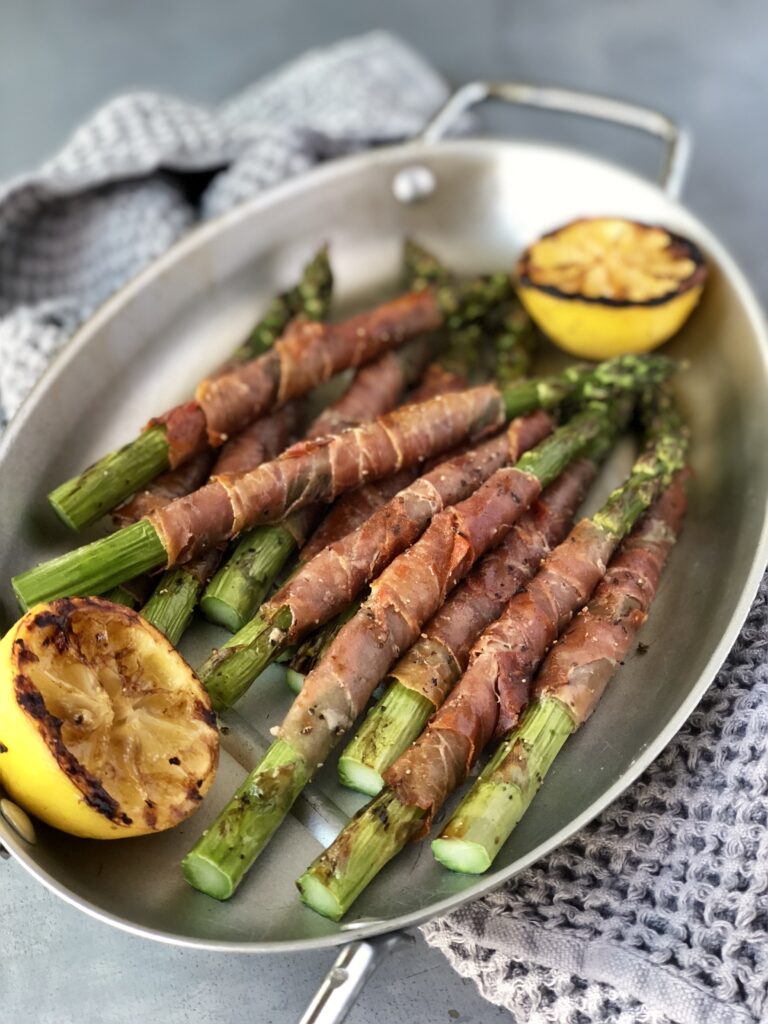 Asparagus spears wrapped in prosciutto on a platter