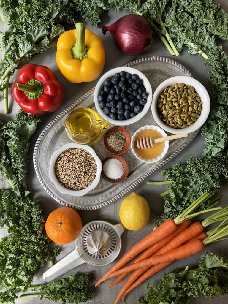 Salad ingredients: bell peppers, red onion, blueberries, quinoa, sunflower seeds, olive oil, quinoa, salt, honey, carrots, kale