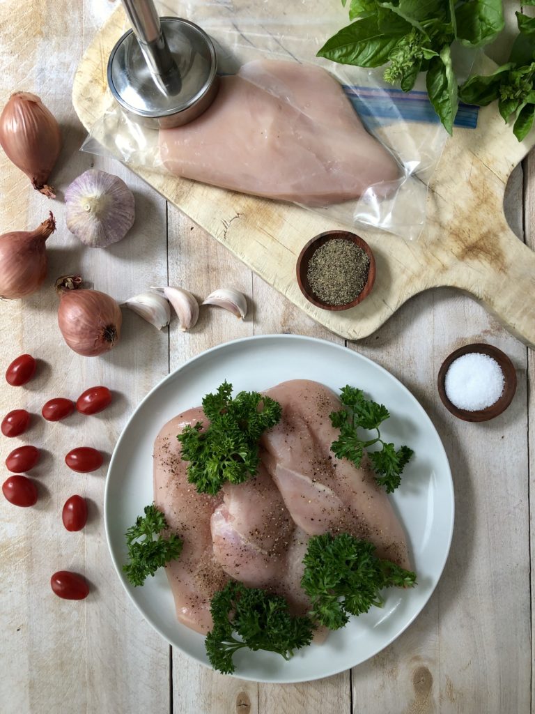 Raw chicken breasts being prepared