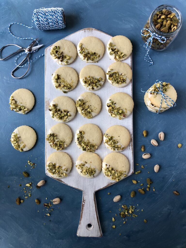 Top down view of decorated cookies on white cutting board.