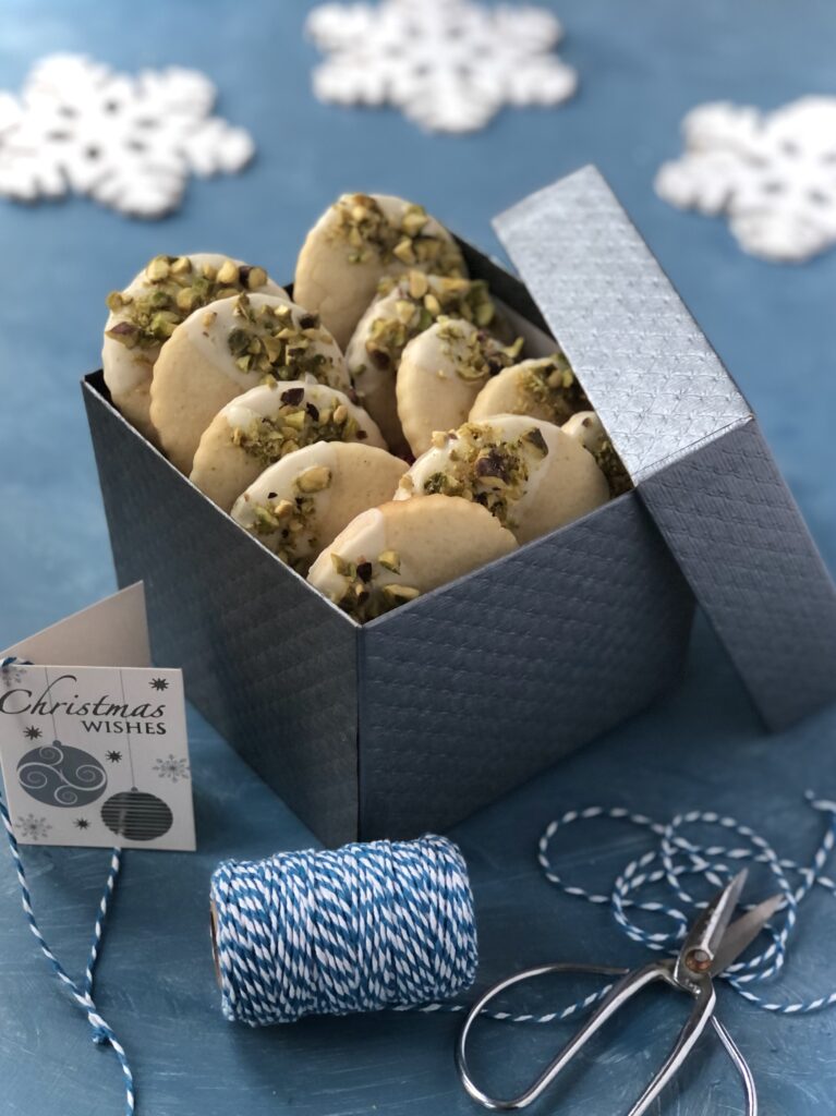 Christmas cookies in a gift box with a tag and twine.