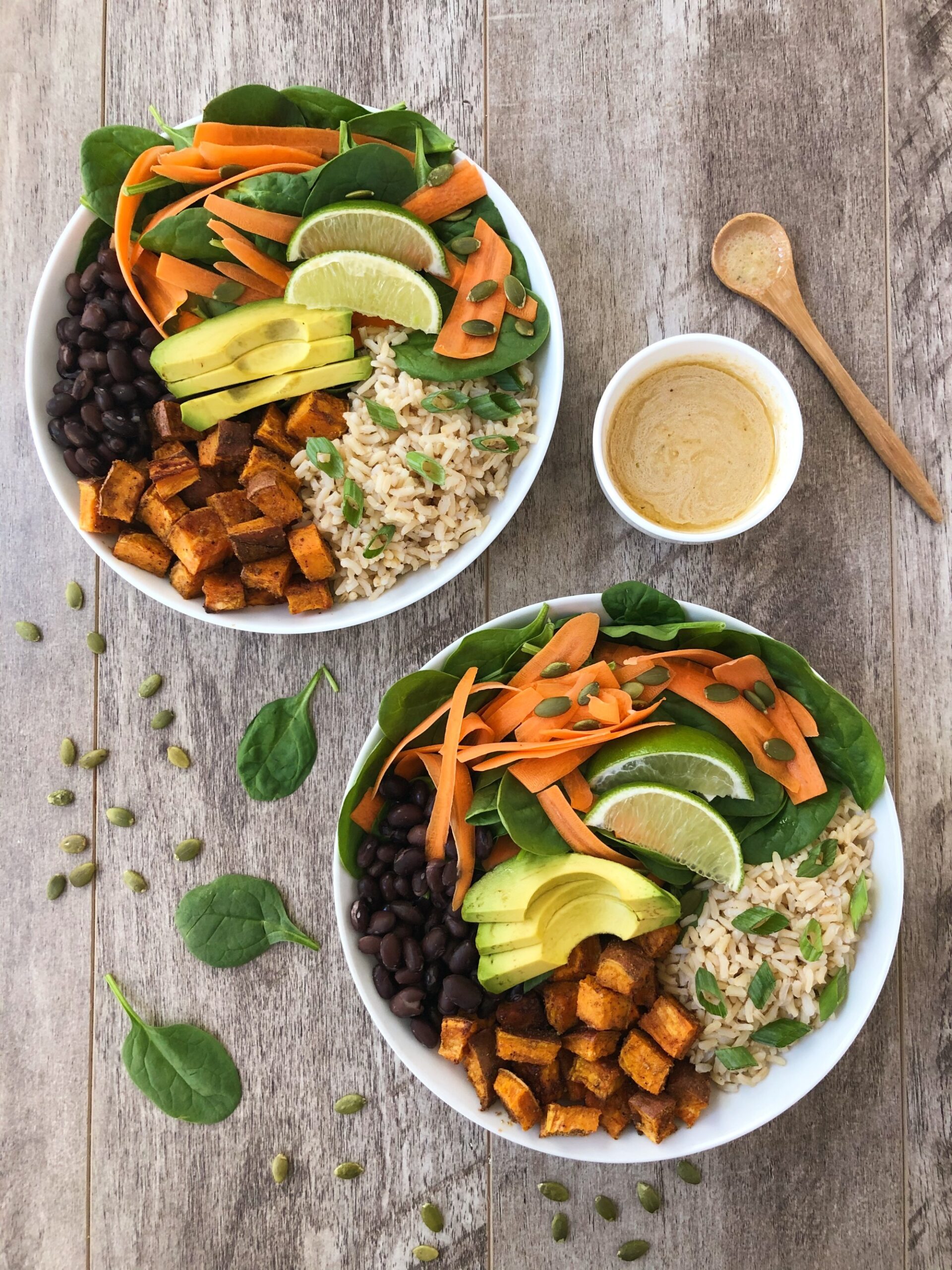 Two large bowls with bowl of dressing on the side