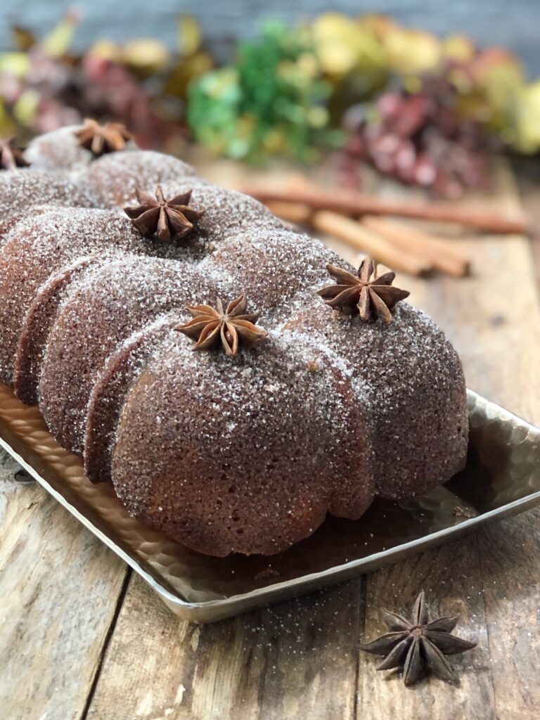 Whole baked apple cider donut cake on a platter.