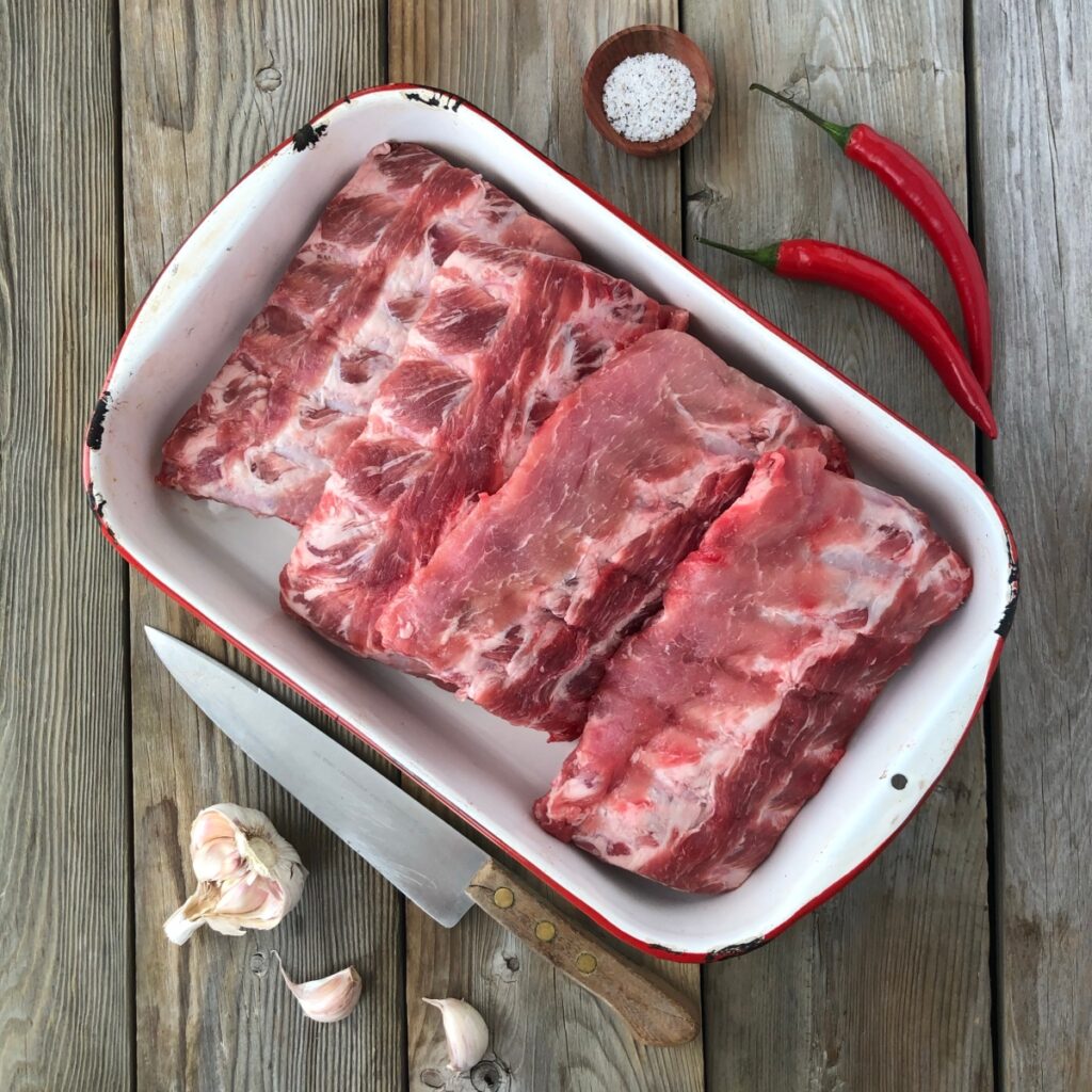 Cut up raw pork ribs in a pan