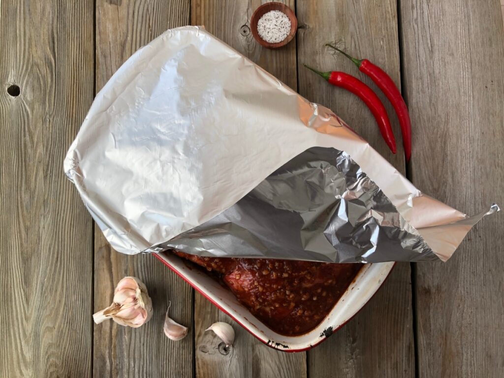 Ribs in baking tray covered in foil wrap ready to be cooked