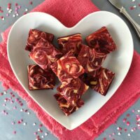 Red velvet brownies arranged on a heart shaped plate.