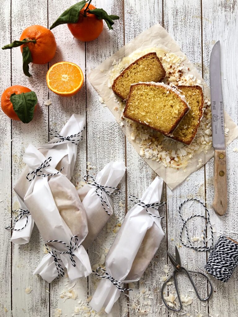 Slices of orange loaf wrapped in parchment paper with string securing it.