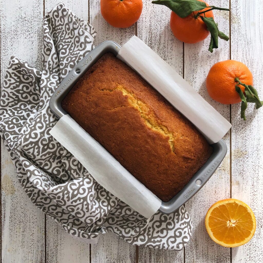 Cake out of the oven baked to a golden brown with a crack on top.