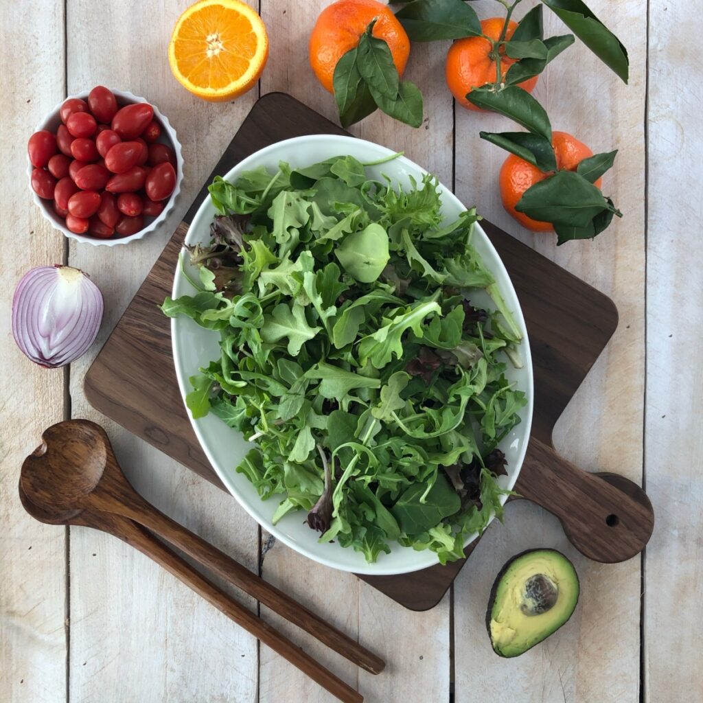 Mixed greens arranged on a platter.