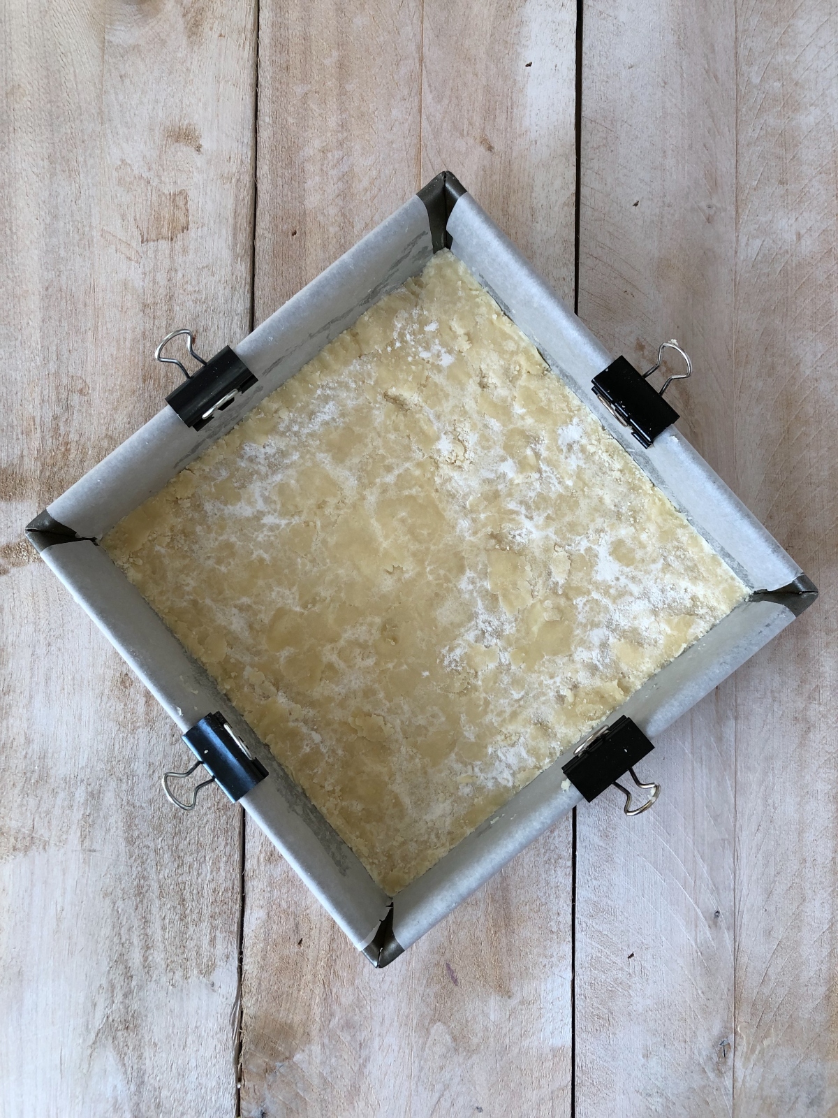 Shortbread crust packed in baking pan.