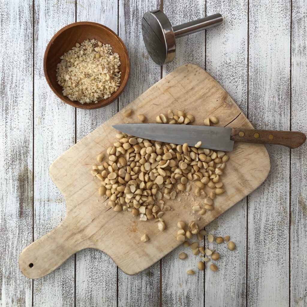 Macadamia nuts chopped on a wood board