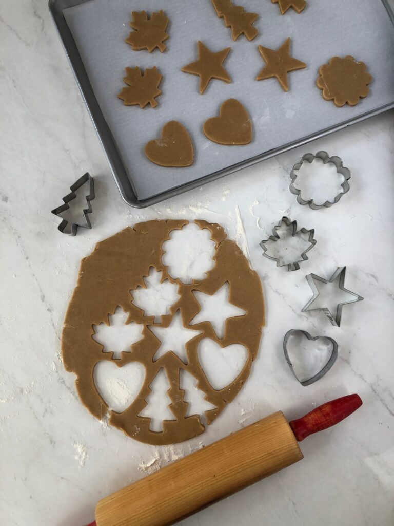 Cookie dough rolled out and cut with cookie cutters