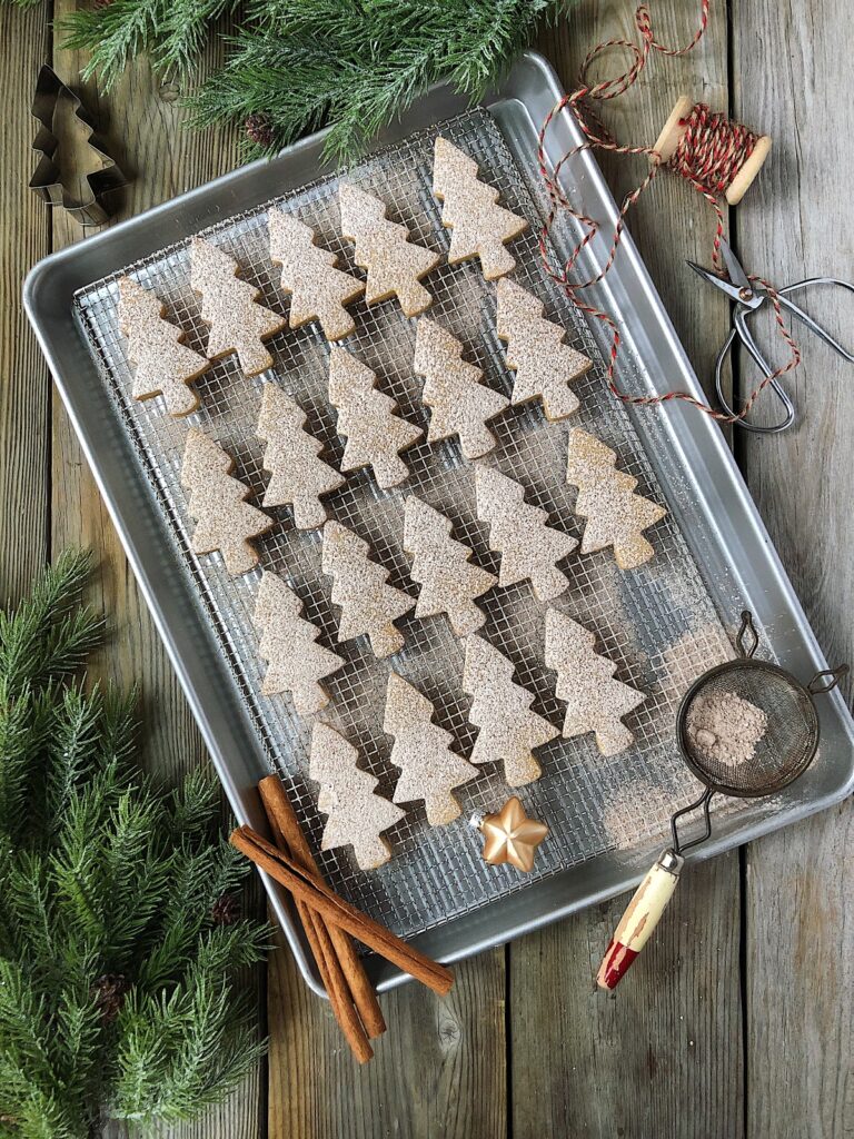 Cinnamon dusted sugar cookies on a rack with a sieve