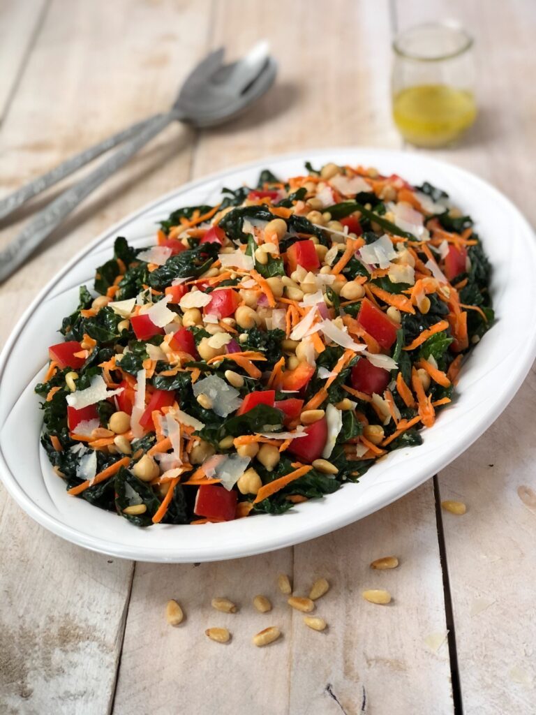 Tuscan kale salad on a platter with vinaigrette in a jar