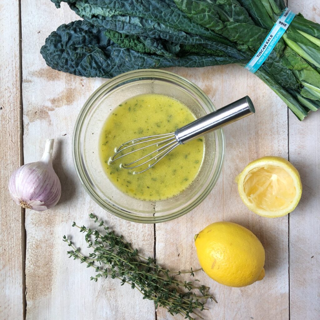 Lemon dressing whisked in a glass bowl.