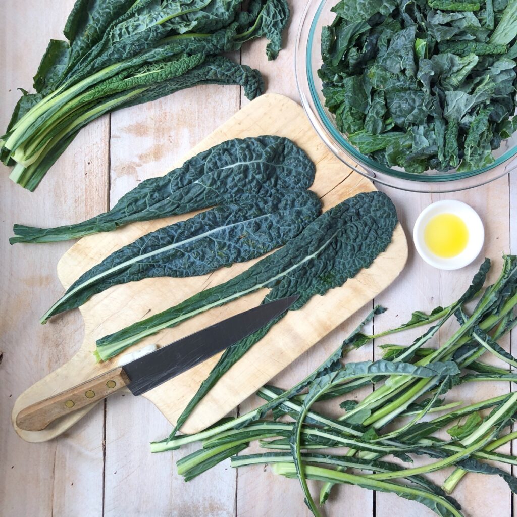 Kale being de-stemmed, cut, them massaged.