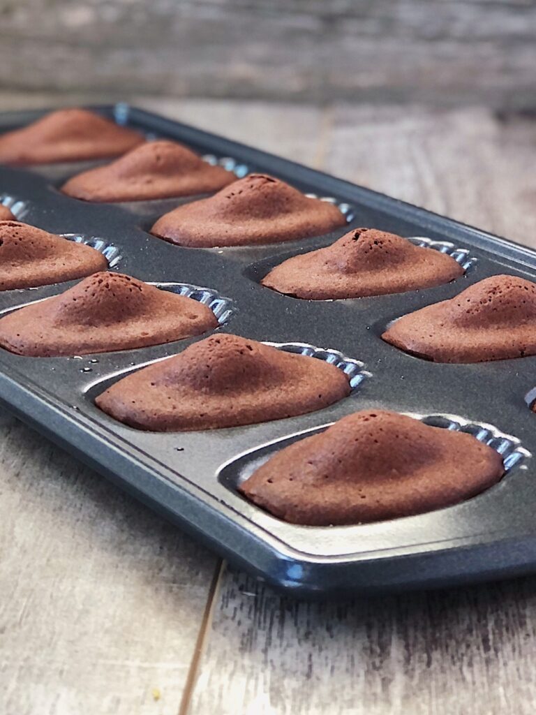 Closeup of baked madeleines with signature hump.