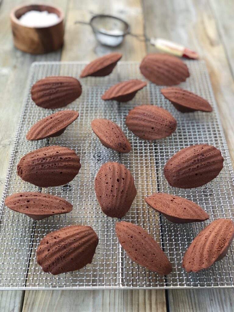 Shell-shaped cakes on a cooling rack showing air holes.