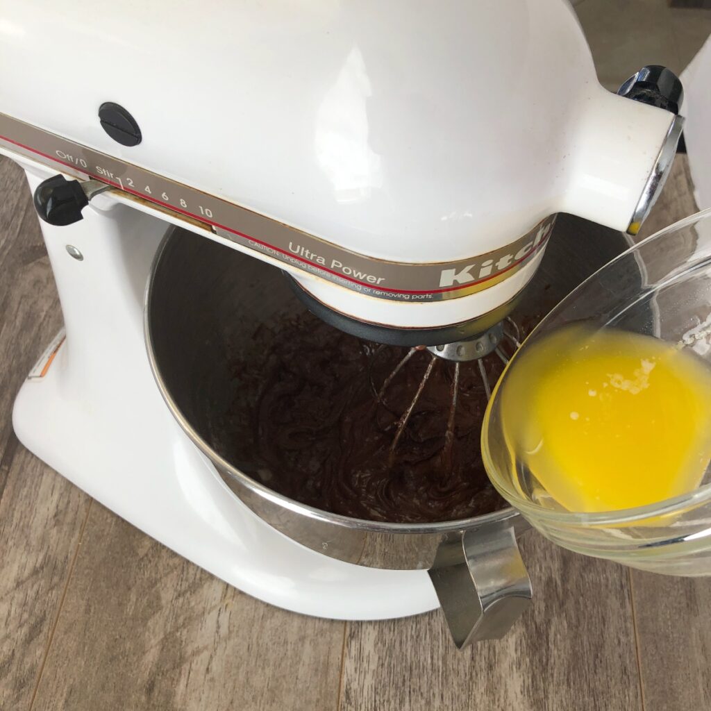 Slowly drizzling butter into batter with mixer.