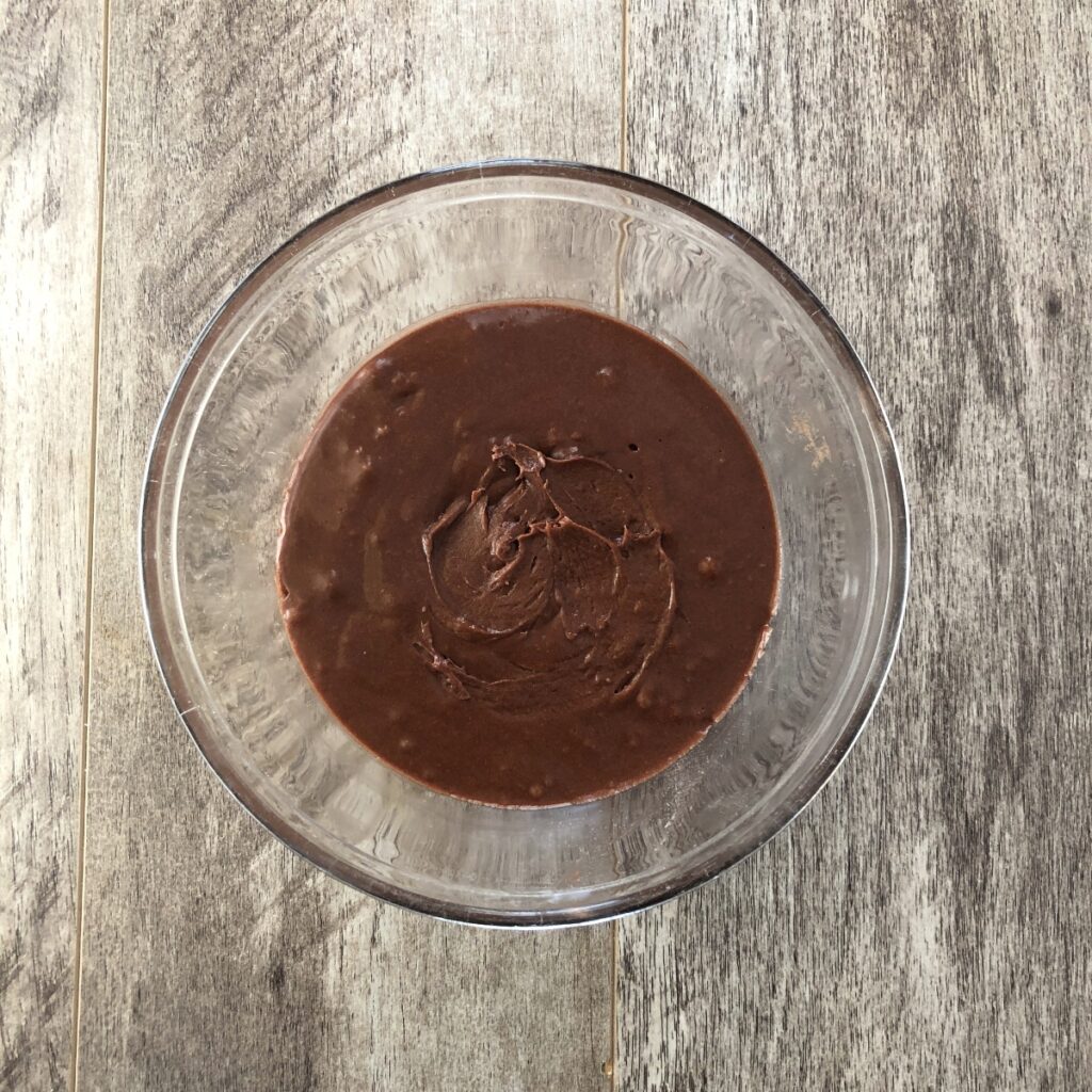 Mixed chocolate madeleine batter in a glass bowl.