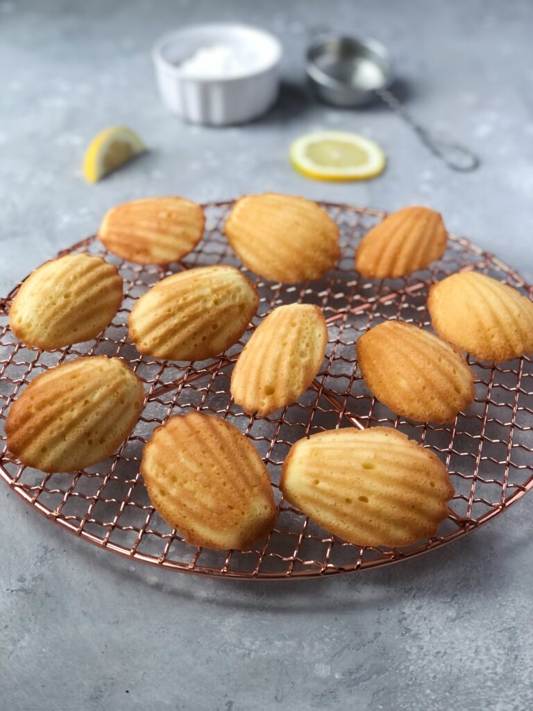 Shell-shaped cakes on a cooling rack showing air holes.