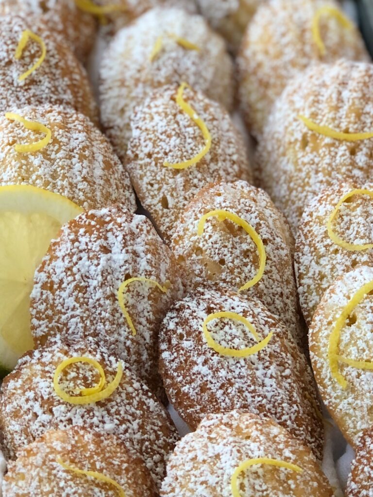 Close up view of shell shaped madeleines with lemon zest garnish.