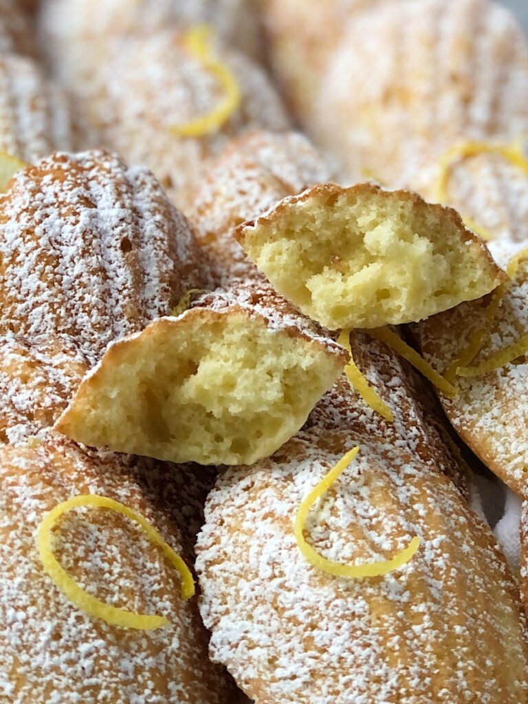 Close up view of Madeleine cake split open showing airy interior.