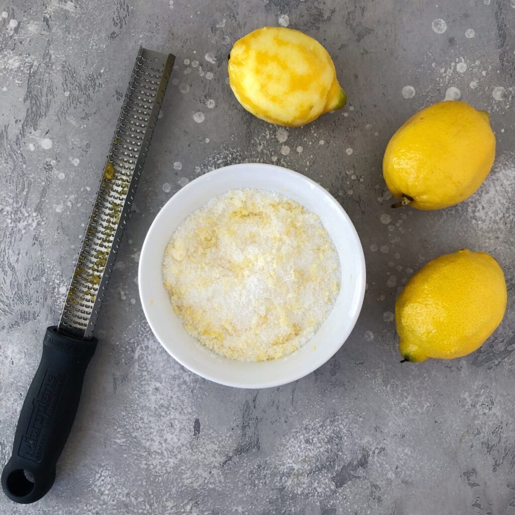 Sugar infused with lemon zest in a small bowl.