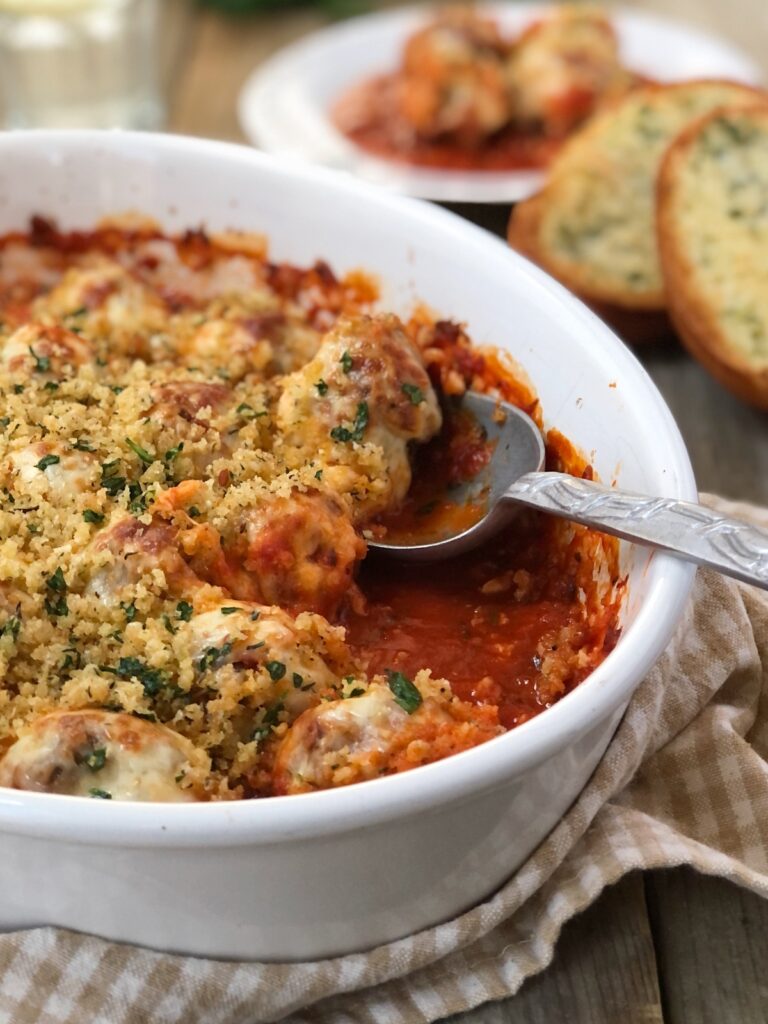 Italian meatball parmesan casserole being served with bread.