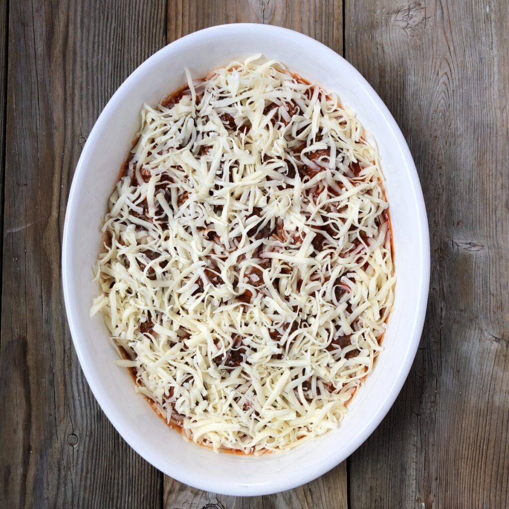 Casserole of meatballs and sauce sprinkled with mozzarella.