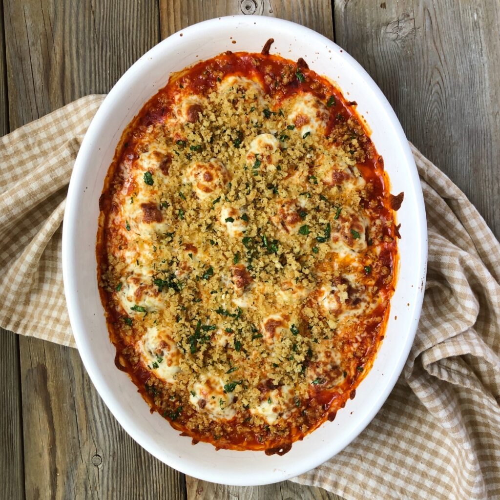 Casserole with baked meatballs sprinkled with breadcrumb topping.