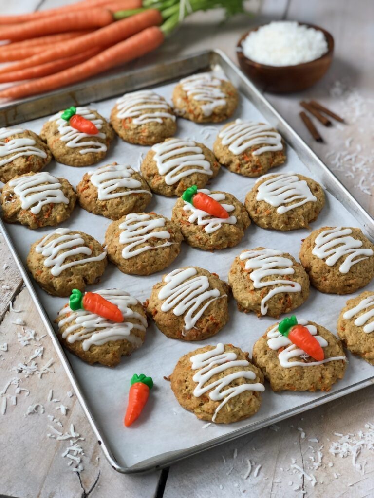 Carrot cake cookies and carrot gummy candies on a tray.