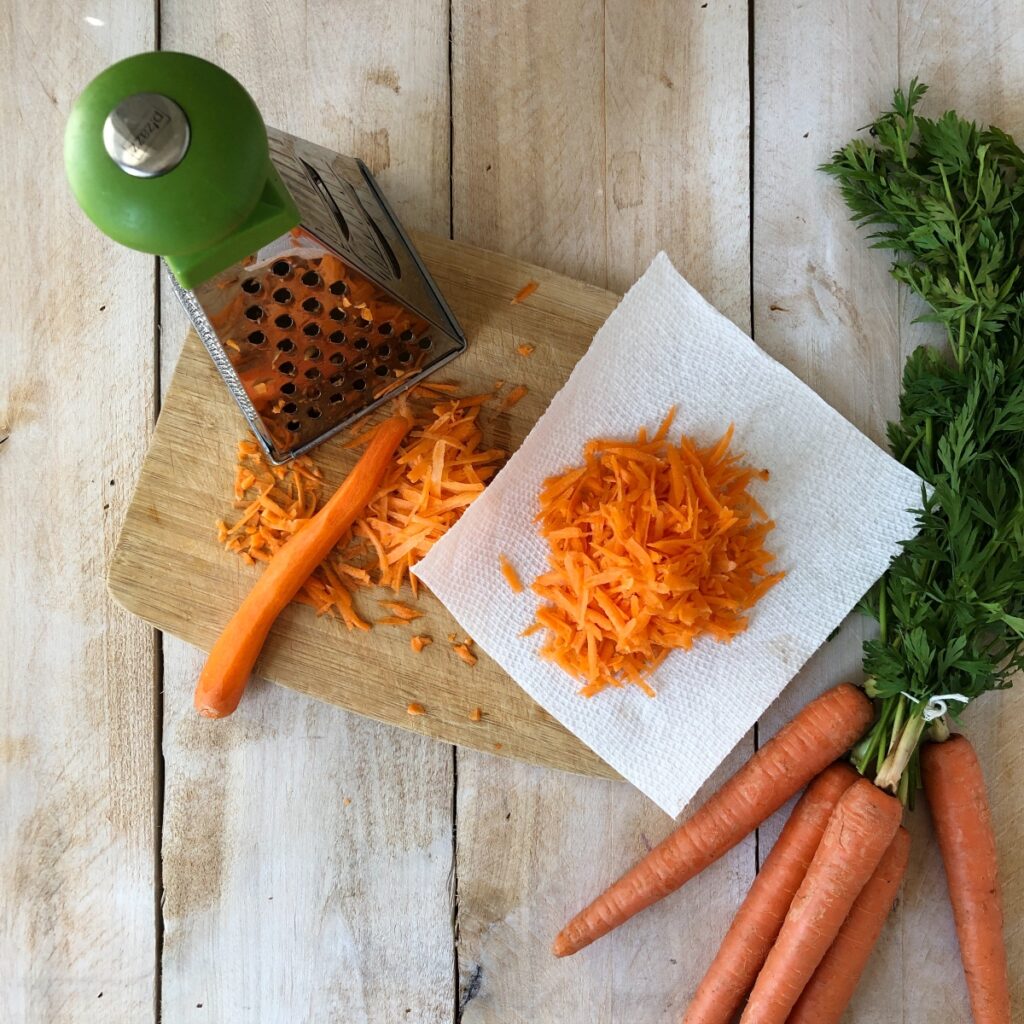 Carrots shredded on a box grater blotted on paper towel.