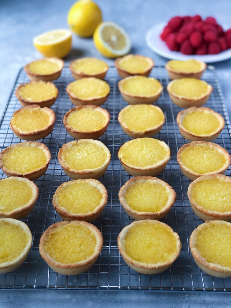 Tartlets on a cooling rack ready for raspberry garnish.