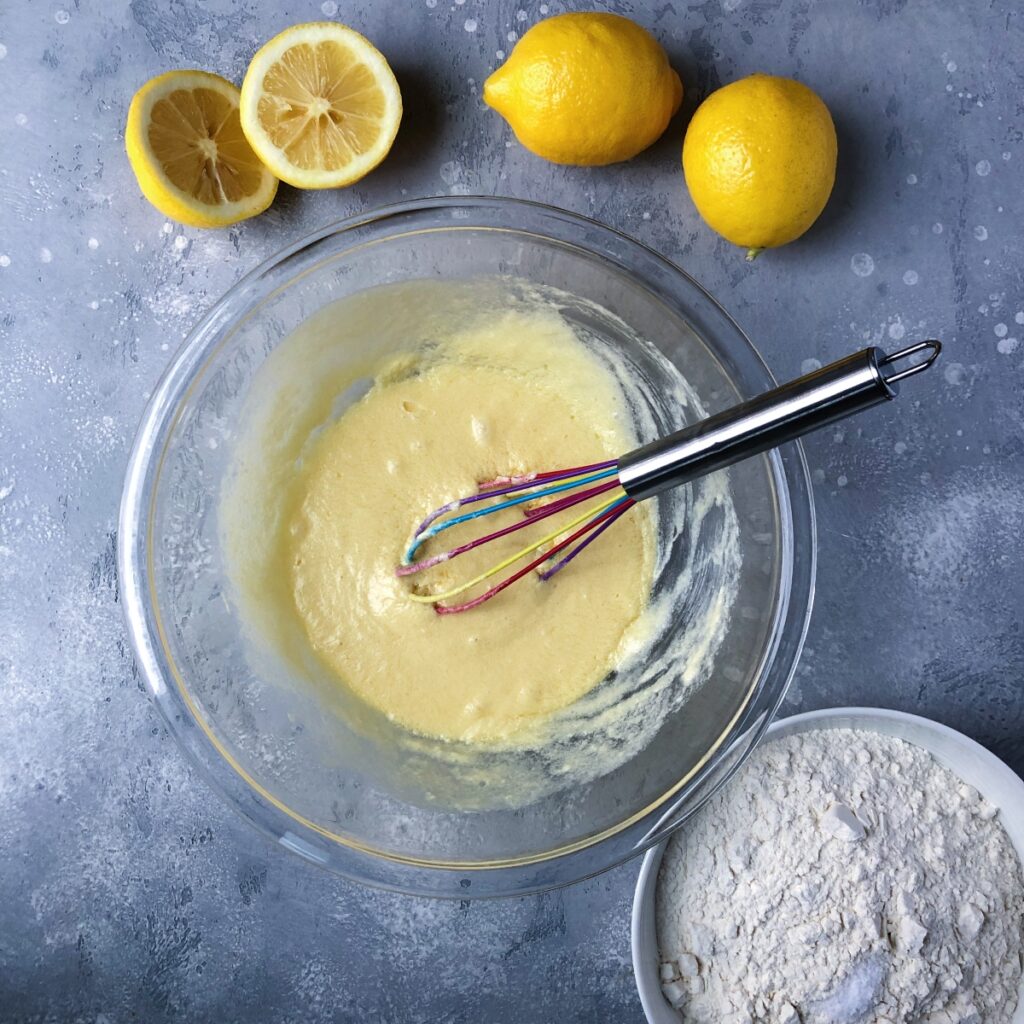 Whisking butter, sugar, eggs and vanilla in a glass bowl.
