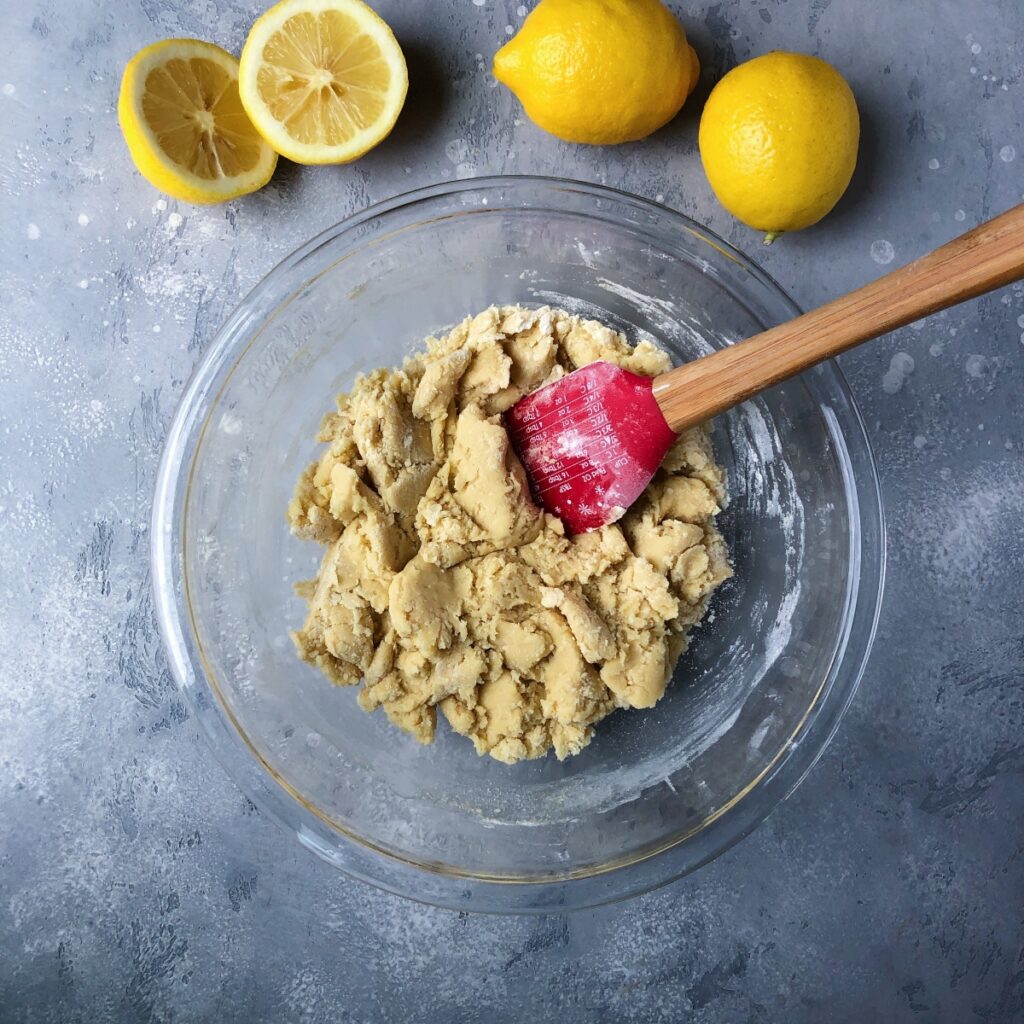 Mixing flour into wet ingredients with a spatula to form a dough.